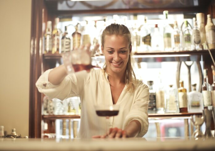 Cheerful Female Bartender Pouring Cocktail In Bar 3771101
