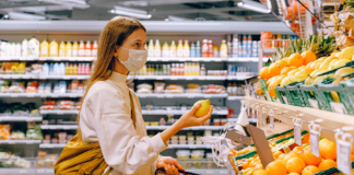 mujer con camisa blanca comprando con mascarilla en el super