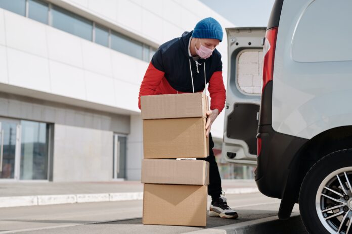 hombre cargando cajas de cartón a furgoneta