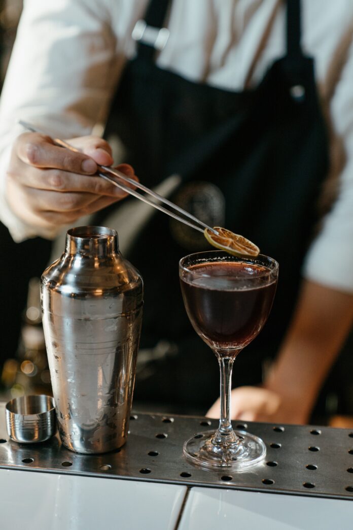 barman sirviendo un cóctel en una copa