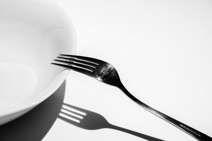 tenedor sobre plato con sombra acentuada