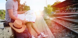 mujer con mapa y mochila esperando al tren