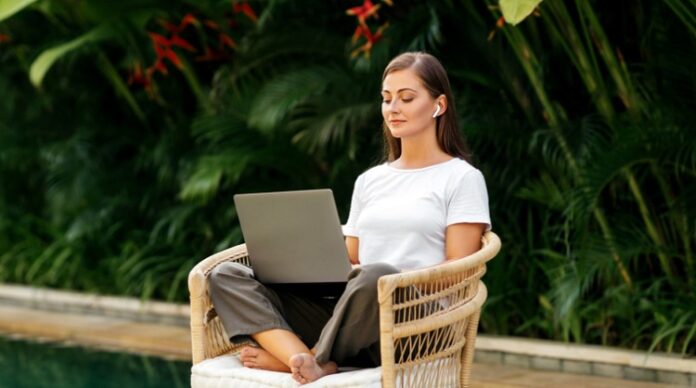 young woman near swimming pool and working at latop computer